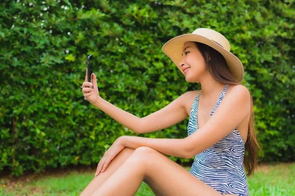 Porträt junge Asiatin mit Smartphone um die Wette — Stockfoto