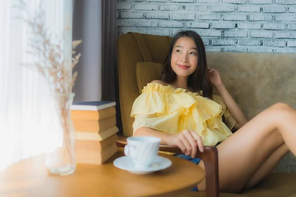 Retrato jovem asiático mulher sentar no sofá cadeira e ler livro com — Fotografia de Stock
