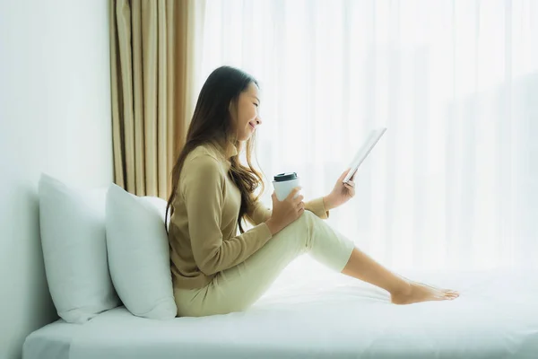 Junge asiatische Frau mit Kaffeetasse und Buch lesen — Stockfoto