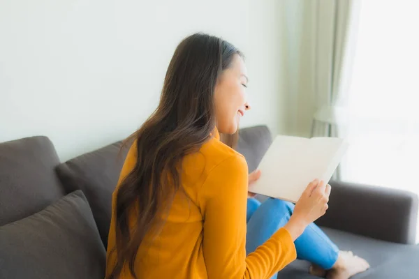 Ritratto giovane donna asiatica leggere libro su divano sedia con cuscino i — Foto Stock