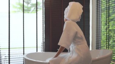 Güzel Asyalı kadının sabun köpüğüyle banyo yaptığı görüntüler.