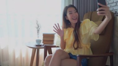 Güzel Asyalı kadının evde akıllı telefon kullandığının görüntüleri.
