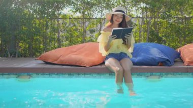 Güzel Asyalı bir kadının oteldeki havuzda dinlenirken çekilmiş görüntüleri.