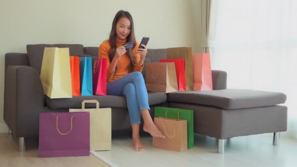 亚洲美女带着彩色纸袋在家中进行电子购物的照片 — 图库视频影像