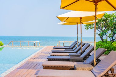 Dışarıda yüzme havuzu etrafında güzel boş bir sandalye şemsiyesi.