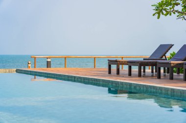 Dışarıda yüzme havuzu etrafında güzel boş bir sandalye şemsiyesi.