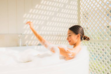 Portre genç Asyalı kadın rahatla küvette banyo yap.