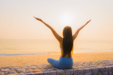Genç Asyalı kadının portresi, deniz kıyısı okyanusunda meditasyon yapıyor. 
