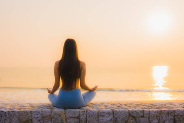 Genç Asyalı kadının portresi, deniz kıyısı okyanusunda meditasyon yapıyor. 