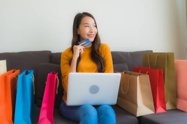 Genç Asyalı kadının akıllı mobili dizüstü bilgisayar kullanan portresi.