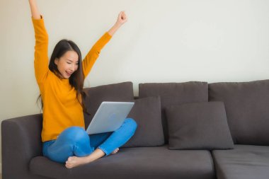 Dizüstü bilgisayarı kullanan Asyalı genç bir kadının portresi.