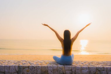 Genç Asyalı kadının portresi, deniz kıyısı okyanusunda meditasyon yapıyor. 