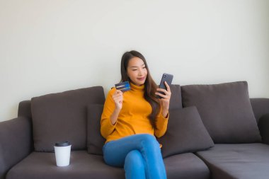 Genç Asyalı kadının akıllı mobili dizüstü bilgisayar kullanan portresi.