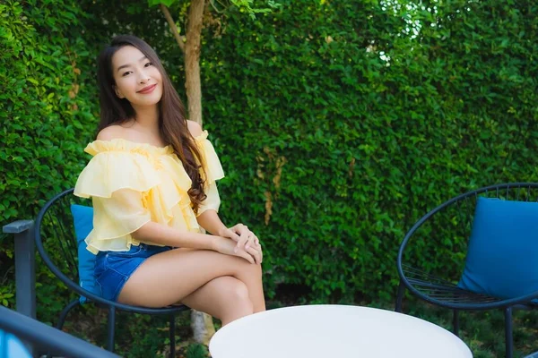 Mladá asijská žena šťastný úsměv relaxovat a sedět na židli — Stock fotografie