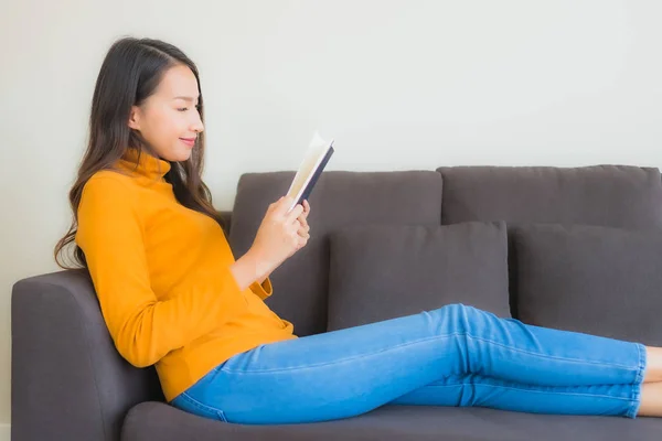 Ritratto giovane donna asiatica leggere libro su divano sedia con cuscino i — Foto Stock