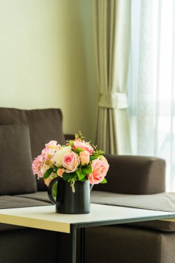 Yastık ve kanepe dekorasyonlu vazo çiçeği.