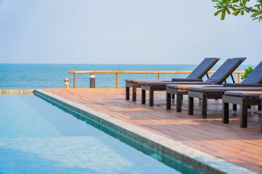 Dışarıda yüzme havuzu etrafında güzel boş bir sandalye şemsiyesi.