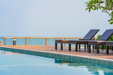 Dışarıda yüzme havuzu etrafında güzel boş bir sandalye şemsiyesi.