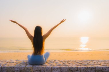 Genç Asyalı kadının portresi, deniz kıyısı okyanusunda meditasyon yapıyor. 