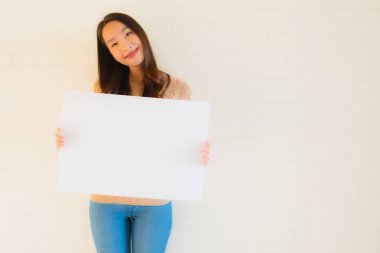 Güzel Asyalı genç kadınların portresi boş beyaz kağıt yaban domuzu gösteriyor.