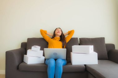 Genç Asyalı kadının portresi P ile çalışmak için dizüstü bilgisayar kullanıyor.