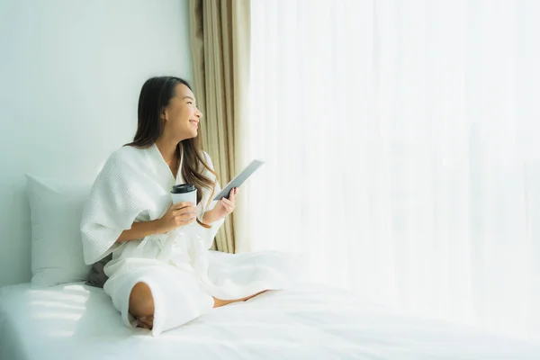 Junge asiatische Frau mit Kaffeetasse und Buch lesen — Stockfoto