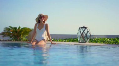 Güzel Asyalı bir kadının oteldeki havuzda dinlenirken çekilmiş görüntüleri.
