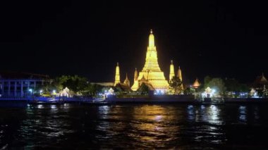 Nehir kıyısındaki güzel aydınlatılmış Asya tapınağının görüntüleri.