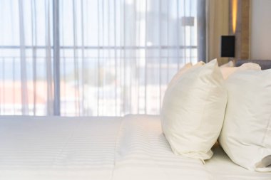 Yatak odasının iç dekorasyonunda beyaz rahat yastık.