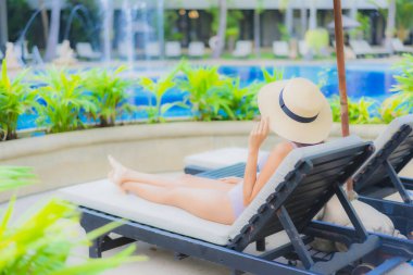 Güzel Asyalı genç kadınların portresi mutlu bir gülümseme otel tatil beldesinde yüzme havuzunda rahatlamak