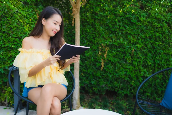 Young asian woman read book around outdoor garden nature view