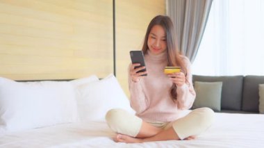 Evinden e-alışveriş yapan güzel Asyalı kadının görüntüleri.