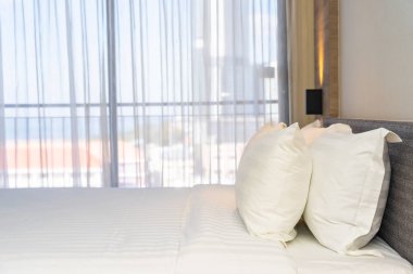 Yatak odasının iç dekorasyonunda beyaz rahat yastık.