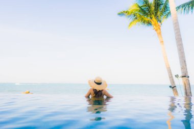 Güzel Asyalı genç kadınların portresi mutlu bir gülümseme otel tatil beldesinde yüzme havuzunda rahatlamak