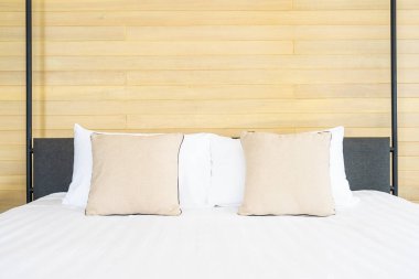 Otel odasındaki yatak odasının iç dekorasyonunda beyaz rahat yastık.