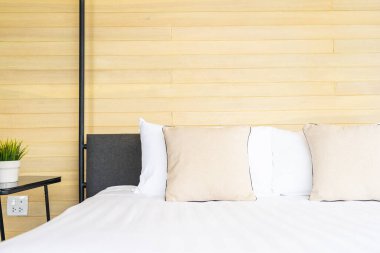 Otel odasındaki yatak odasının iç dekorasyonunda beyaz rahat yastık.