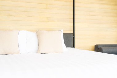 Otel odasındaki yatak odasının iç dekorasyonunda beyaz rahat yastık.