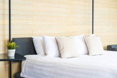 Otel odasındaki yatak odasının iç dekorasyonunda beyaz rahat yastık.