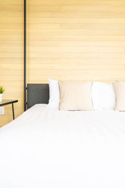 Otel odasındaki yatak odasının iç dekorasyonunda beyaz rahat yastık.