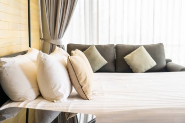 Otel odasındaki yatak odasının iç dekorasyonunda beyaz rahat yastık.