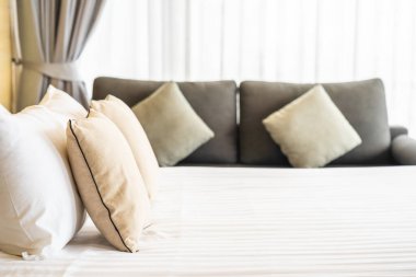 Otel odasındaki yatak odasının iç dekorasyonunda beyaz rahat yastık.