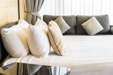 Otel odasındaki yatak odasının iç dekorasyonunda beyaz rahat yastık.