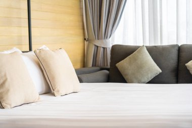 Otel odasındaki yatak odasının iç dekorasyonunda beyaz rahat yastık.