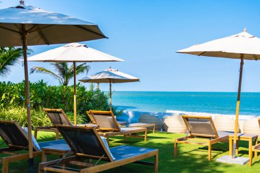 Şemsiye ve sandalye deniz kıyısında seyahat için.