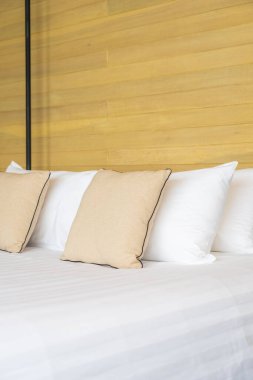 Otel odasındaki yatak odasının iç dekorasyonunda beyaz rahat yastık.