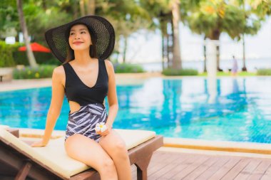 Güzel Asyalı genç kadınların portresi. Mutlu bir gülümseme. Yüzme havuzunda rahatla.