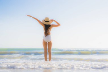 Güzel bir Asyalı kadın portresi. Okyanus sahillerinde mutlu bir gülümseme ve tatil için mavi bir gökyüzü.