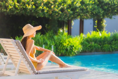 Güzel bir Asyalı kadın portresi. Mutlu bir gülümseme. Keyifli bir tatil için otel havuzunda rahatça yüzme havuzu.
