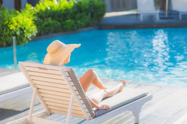Güzel bir Asyalı kadın portresi. Mutlu bir gülümseme. Keyifli bir tatil için otel havuzunda rahatça yüzme havuzu.