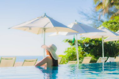 Güzel bir Asyalı kadın portresi. Mutlu bir gülümseme. Keyifli bir tatil için otel havuzunda rahatça yüzme havuzu.